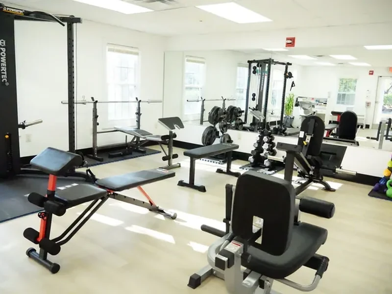 Weight racks and benches on the training floor at Youtherapy Wellness and Physical Rehab in Milford