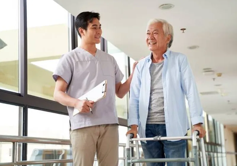 Older adult practicing balance training with a therapist close by